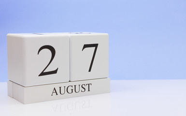 August 27st. Day 27 of month, daily calendar on white table with reflection, with light blue background. Summer time, empty space for text