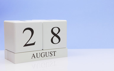 August 28st. Day 28 of month, daily calendar on white table with reflection, with light blue background. Summer time, empty space for text