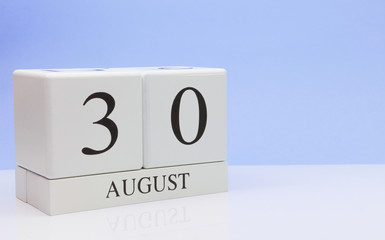 August 30st. Day 30 of month, daily calendar on white table with reflection, with light blue background. Summer time, empty space for text
