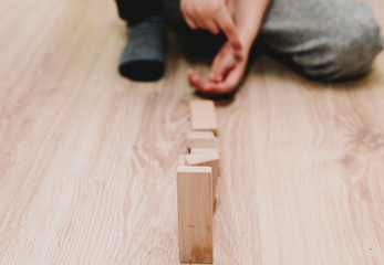 Breaking wooden blocks like domino blocks. The little boy has put together wooden blocks that will...
