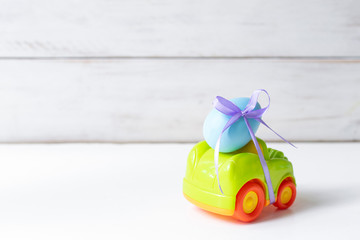 Easter cars with an egg on a white background, the concept of the approaching easter