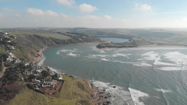 Forward moving drone shot of beaches and ocean, with small coastal towns, Devon UK
