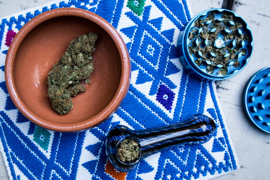 Marijuana in Blue Pipe with Grinder and Bowl of Cannabis (Overhead)