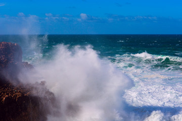 Sea waves hitting rocks cliff at Praia Da Bordeira, Portugal