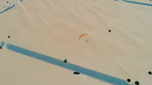 Aerial view of a man using powered parachute at desert landscape, Dubai, U.A.E.