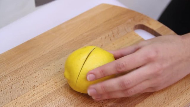Knife a cutting juicy lemon on a white background.