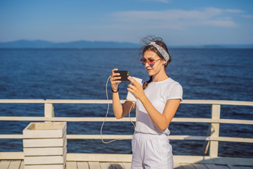 Cruise ship woman using mobile phone on travel vacation at ocean. Girl texting sms on wifi on...