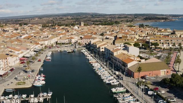 Flying over M&egrave;ze harbor along the basin de Thau sunny day sailing boats and lighthouse