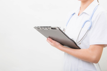 Hands of young nurse writing on a clipboard