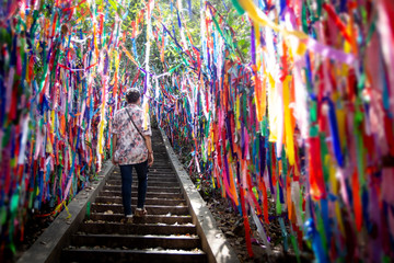 A young woman standing between colorful fabric ribbons. Background for tourist attractions, religious sites, holy places 