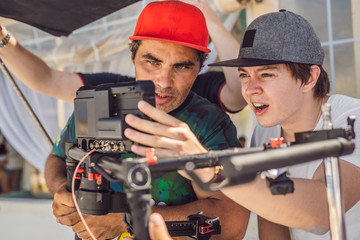 the production team on a commercial video shoot. Steadicam operator uses the 3-axis camera...