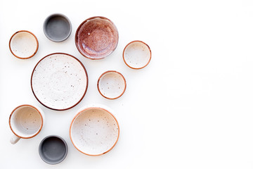 Ceramic tableware pattern. Empty plates and mugs on white background top view copy space