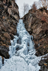 Fototapeta na wymiar Frozen waterfall Finsterbach in march in the mountains. Ossiach, Carinthia, Austria