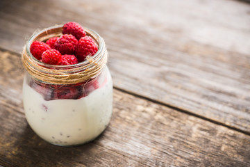 Healthy refreshment breakfast with yogurt, frozen raspberry and chia seeds. Selective focus. Shallow depth of field.
