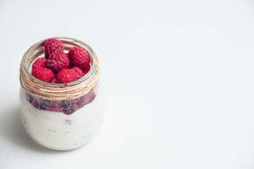 Healthy refreshment breakfast with yogurt, frozen raspberry and chia seeds. Selective focus. Shallow depth of field.