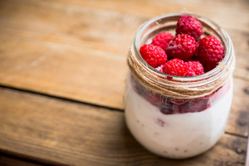 Healthy refreshment breakfast with yogurt, frozen raspberry and chia seeds. Selective focus. Shallow depth of field.