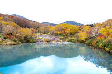 Naklejka premium Jigokanuma pond view in panorama, soft blue pond with water reflection of trees shadows at Aomori Tohoku prefecture in autumn season,Japan