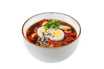 Traditional Italian minestrone soup with meat, celery, tomatoes, bell pepper and pasta in a bowl isolated on white background.