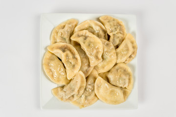 Dumplings on a white plate for cutting