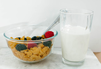 Granola, cereal with berries and a glass of milk