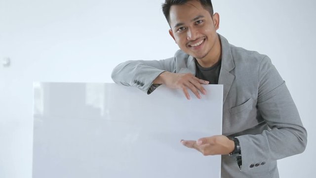 Pose of young business man holding and pointing a free space