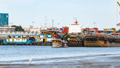 Cargo Ship and Tugboat at Estuary with Containers