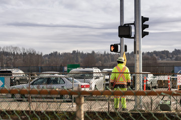 Road worker monitoring traffic at construction site