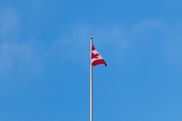 Canadian flag against bright blue sky