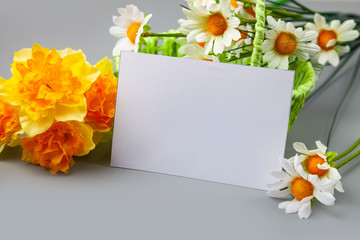 Bouquet of spring flowers in a basket and a card