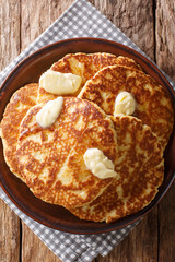 Delicious Sweet Griddle Cakes with butter close-up on a plate. Vertical top view
