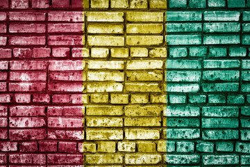 National flag of Guinea on a brick background. Concept image for Guinea: language , people and culture.