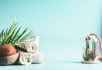 Spa background. Rolled towels, compress balls with coconut, palm leaves and various succulent...