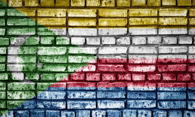 National flag of Comoros on a brick background. Concept image for Comoros: language , people and culture.