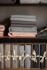 wooden wardrobe with linens and clothes at home or in a store, design concept in the interior