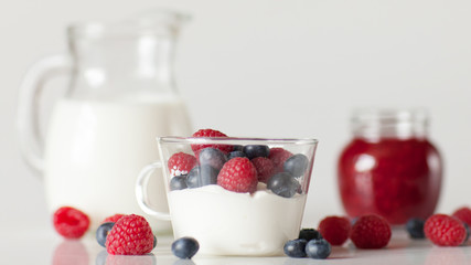 Yogurt with blueberry and raspberry berries in a glass Cup on a white background. Breakfast. Healthy diet.