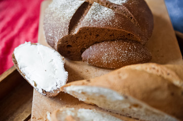 Sliced baguette and round rye black bread. Sandwich with bread, butter and dill. White loaf and rye bread close up and copy space