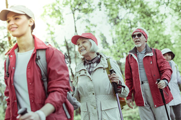 Fototapeta premium Elderly woman feeling inspired during hiking in forest
