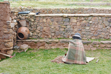 Native american old woman working with potato in the countryside.