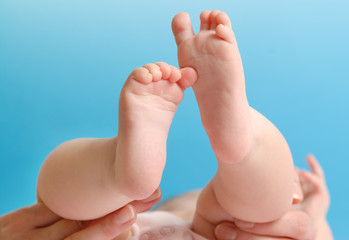 Feminine palm holding a baby foot