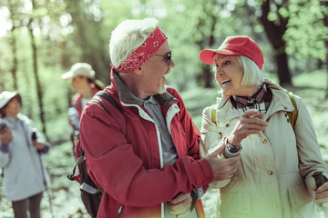 Emotional elderly couple enjoying walking in the forest