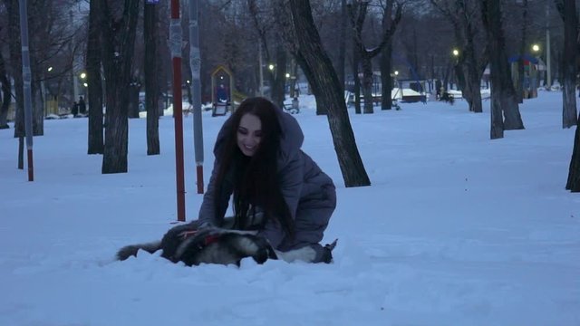 Beautiful Young Woman Playing With A Dog In A Winter Snowy Park