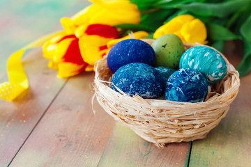 Fototapeta na wymiar Easter eggs and tulips on wooden planks