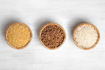 Wheat, buckwheat and rice in wooden plates. The view from the top.