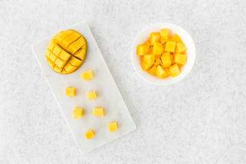 Cut Mango Half and Mango Cubes on Marble Cutting Board
