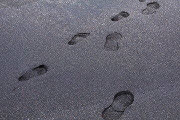 Footprints on black sand