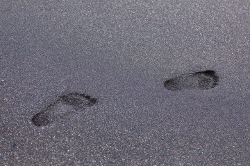 Footprints on black sand