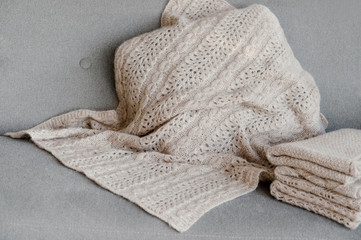 The plaid hand work is lying on the couch