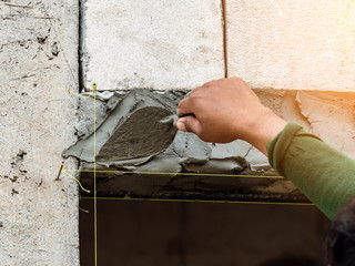 plasterer concrete worker at wall of house construction