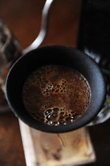 Coffee blooming in porous ceramic paperless dripper filter. Close up. Alternative manual brewing....
