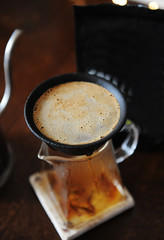 Alternative manual coffee brewing in porous ceramic paperless dripper filter. Close up. Gooseneck...